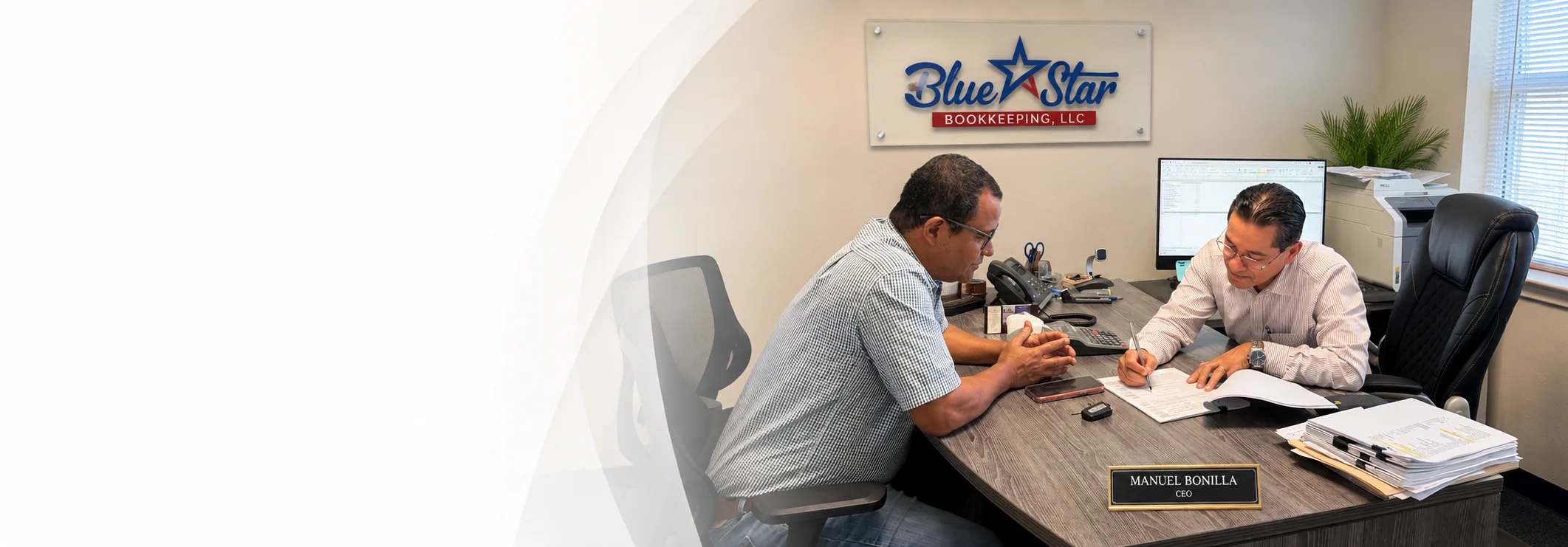 Manuel Bonilla, propietario de Blue Star Bookkeeping, ayudando a un cliente en la oficina de Austin